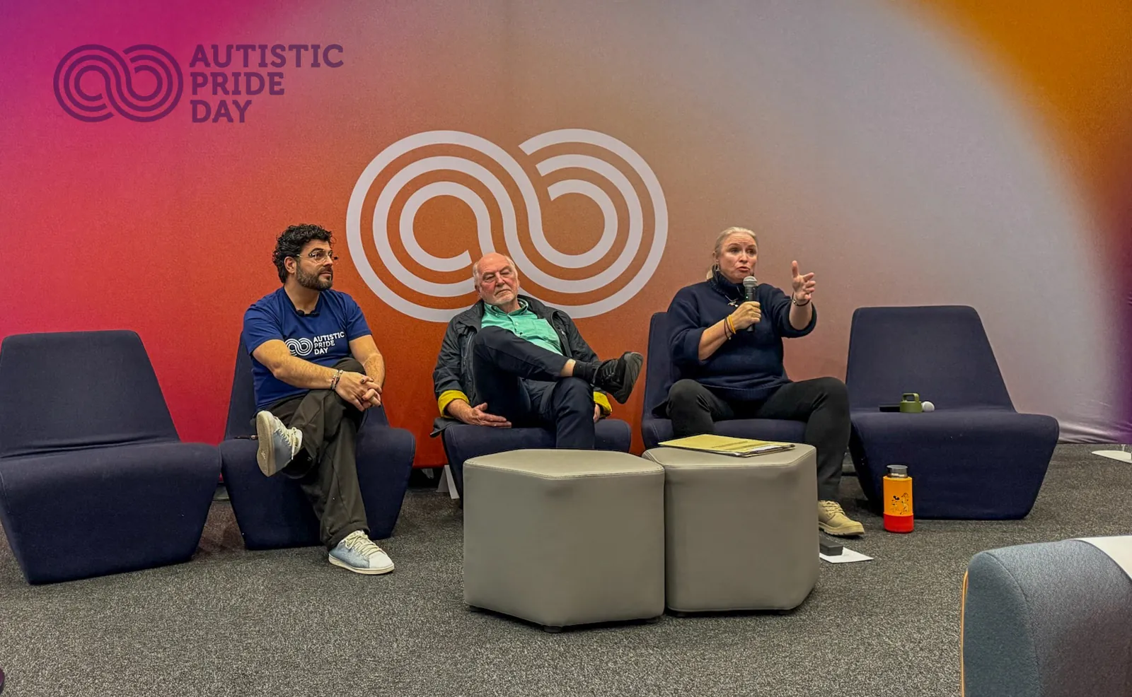 Kyriakos Gold with two panellists on stage at Autistic Pride Day 2026